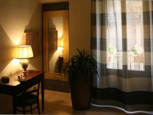 ヴァストにあるB&B Dolce Casaのデスク、植物のある窓が備わる客室です。