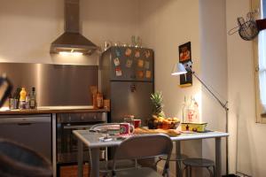 a kitchen with a table with chairs and a refrigerator at L'Aristoloche in Salins-les-Bains