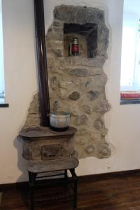 a stone wall with a stove in a room at La casa di Nonna Nilla in San Giovanni Bianco