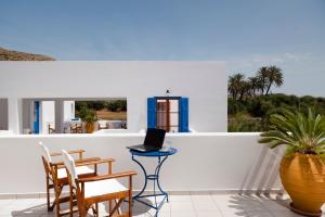 - un balcon avec une table et un ordinateur portable dans l'établissement Hotel Eleni, à Adamas