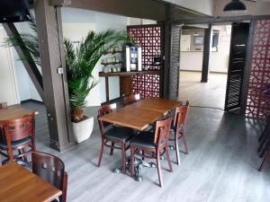 a dining room with a wooden table and chairs at Hotel Wood Inn Bordeaux Aéroport in Mérignac