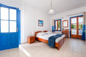 a bedroom with a bed and a blue door at Hotel Eleni in Adamantas