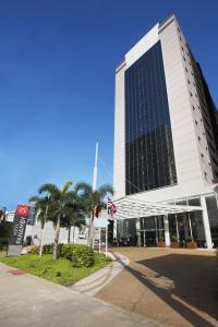 un edificio alto con una bandera delante de él en Hotel Panamby São Paulo en São Paulo