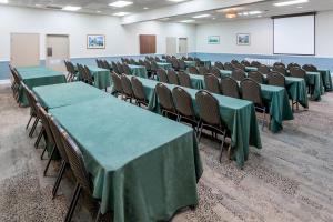 einen Konferenzraum mit grünen Tischen und Stühlen in der Unterkunft Ramada Plaza by Wyndham Nags Head Oceanfront in Kill Devil Hills + 29 Fotos