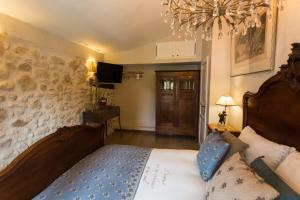 a bedroom with a bed and a chandelier at La Bergerie in Saint-Jeannet