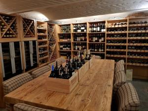 a large wooden table with bottles of wine on it at Provincja Winebar & Rooms in Olsztyn