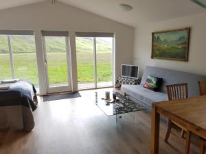 a living room with a couch and a table at Bólstaðarhlíð - Cottage (studio) in Bólstaðarhlíð