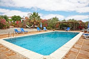 a swimming pool with chairs and a hammock in a yard at Casa Saramago in Monsaraz