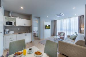 cocina y sala de estar con sofá y mesa en Apartments & Rooms Preelook, en Opatija