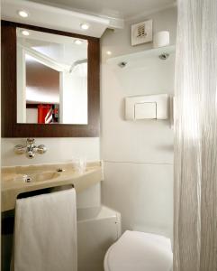 a bathroom with a toilet and a sink and a mirror at Premiere Classe Bourges in Bourges