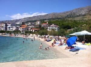 a group of people on a beach in the water at Apartman Luna in Dugi Rat