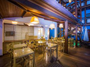 a restaurant with tables and chairs in a room at Pousada Paraíso do Forte in Praia do Forte