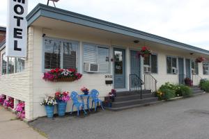 une maison avec des chaises et des fleurs devant elle dans l'établissement Town & Beach Motel, à Falmouth