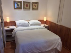 1 dormitorio con 1 cama blanca y 2 mesitas de noche en Ipa Prudente Pent 02, en Río de Janeiro