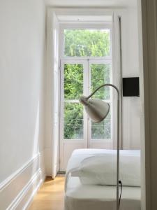 ポルトにあるPorto Republica Riversideのベッドルーム1室(ベッド1台付)、窓の前にランプが備わります。
