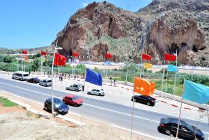 a highway with cars and flags on the road at Appart Clim Wifi 700m de la Plage in Saïdia