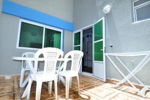 a dining room with white chairs and a table at Appart Clim Wifi 700m de la Plage in Saïdia