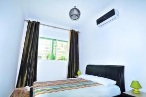 a bedroom with a bed and a tv and a window at Appart Clim Wifi 700m de la Plage in Saïdia
