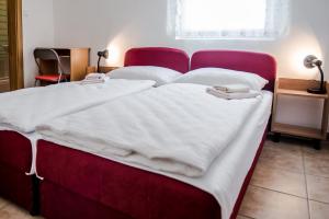 ein rotes Bett mit weißen Laken und Handtüchern darauf in der Unterkunft Ana Stjepan Nikolic - Pilgrim's 2nd home in Međugorje