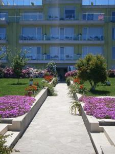 un bâtiment avec un jardin de fleurs devant lui dans l'établissement Villa Flaga, à Sozopol