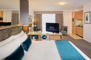 a hotel room with a large bed and a tv at Treasury on Collins in Melbourne