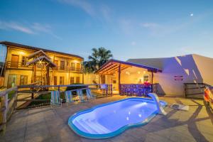 a swimming pool in a yard with a house at Pousada Muito Bonito in Bonito