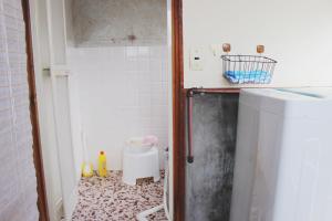a small bathroom with a small refrigerator in it at Guesthouse Ogawaya in Tanabe