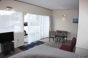 Ala Moana Motel في بيهْيا: غرفة نوم بسرير وطاولة مع كراسي