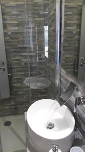 a bathroom with a white sink and a shower at Casa del nonnino in Chiaramonte Gulfi