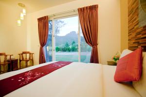 una camera da letto con un letto e una grande finestra di Millennium Inn II a Kenting