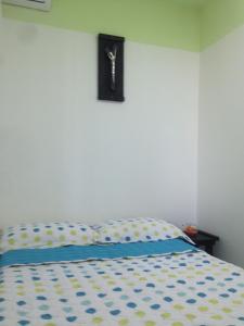 1 dormitorio con 1 cama con reloj en la pared en Apartamento Tolu, en Tolú