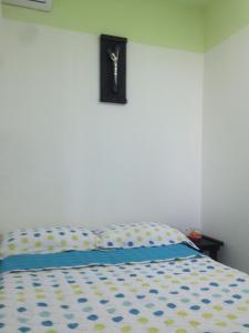 Un dormitorio con una cama con un reloj en la pared. en Apartamento Tolu, en Tolú
