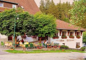 a group of people sitting at tables in front of a building at Pension Löffelschmiede in Lenzkirch