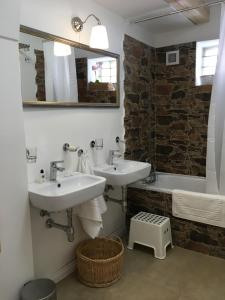 a bathroom with two sinks and a mirror and a tub at House Apartmentshumpolec + Garden in Humpolec