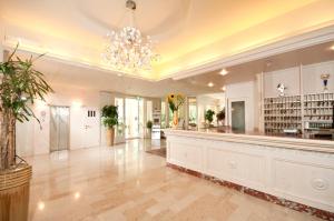 a large lobby with a chandelier and a bar at Hotel Doge in Milano Marittima