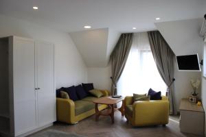 ein Wohnzimmer mit einem Sofa und 2 Stühlen in der Unterkunft Palanga Deluxe 2 in Palanga