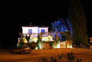a white house with a car parked in front of it at Cavo Christo in Petra