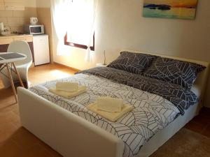 a bedroom with a bed with two towels on it at Apartments Merion in Starigrad