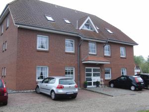 a house with two cars parked in front of it at Haus Antonie 1. Etage in Dahme