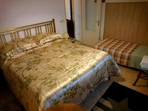 ein Schlafzimmer mit einem Bett mit einer Decke darauf in der Unterkunft Casa San Martino in Teglio