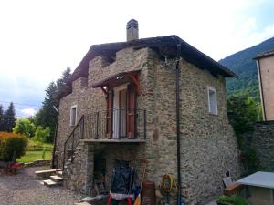 ein altes Steinhaus mit Balkon an der Seite in der Unterkunft Casa San Martino in Teglio