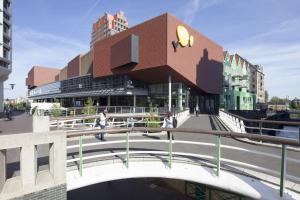 a building on a bridge with people walking on it at easyHotel Amsterdam Zaandam in Zaandam