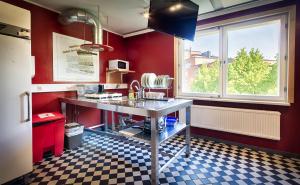 a kitchen with red walls and a checkered floor at Eurohostel in Helsinki