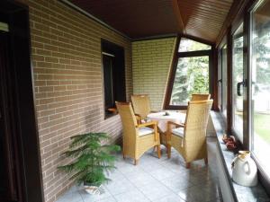 a porch with a table and chairs and a plant at Ferienhaus Lagenhof! Keine Monteure! in Gablenz