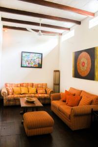 a living room with orange couches and a table at Auberge de Saint Aubin in LʼUnion