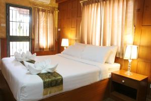 een slaapkamer met een bed met witte bloemen erop bij Orchid Resort in Lat Krabang