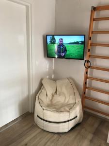 a living room with a white chair and a flat screen tv at Apartment Kiara in Omišalj +23 photos