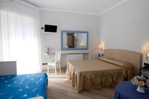 ein Hotelzimmer mit einem Bett und einem Spiegel in der Unterkunft Hotel Il Gatto in Rapallo