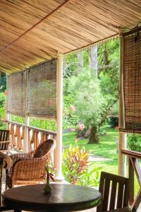 eine abgeschirmte Veranda mit einem Tisch und Stühlen in der Unterkunft Auberge de Saint Aubin in LʼUnion