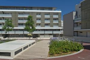 a building with a wooden walkway in front of a building at Quintessens in Marseille